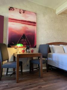 ein Schlafzimmer mit einem Bett und einem Tisch mit einer Lampe in der Unterkunft Mountain Harbor Queen Guest Room on Lake Ouachita in Mount Ida