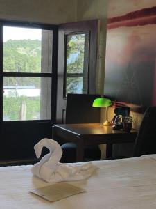 ein Hotelzimmer mit einem Handtuch auf einem Bett mit einem Schreibtisch in der Unterkunft Mountain Harbor Queen Guest Room on Lake Ouachita in Mount Ida + 22 Fotos