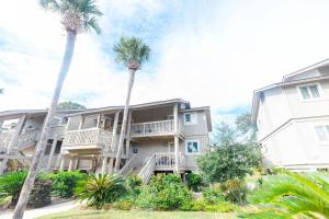 a building with two palm trees in front of it at Lagoon Villa 25 - Heart of Wild Dunes, Quick Walk to Beach in Isle of Palms