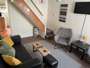 a living room with a couch and a chair at Historic Town Centre Cottage in Bury Saint Edmunds