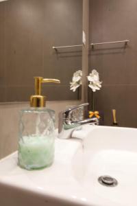 a bottle of soap sitting on a bathroom sink at Sunset Retreat 1a linha de mar in Monte Gordo