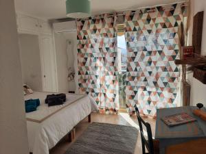 een slaapkamer met een bed, een tafel en een raam bij Appart proche plage avec grand balcon in Cannes