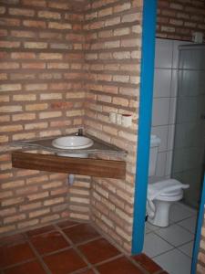 uma casa de banho com um lavatório numa parede de tijolos em Oh! Linda Pousada em Redonda