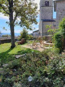 einen Garten mit Stühlen, einem Baum und einem Turm in der Unterkunft Chateau De Riverie chambres et table d'hôtes in Riverie