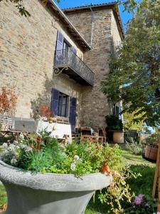 a stone planter with flowers in front of a house at Chateau De Riverie chambres et table d'hôtes in Riverie