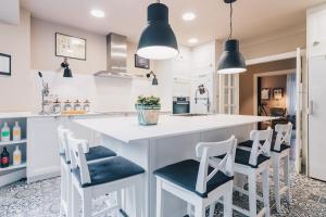a kitchen with white counters and white stools at Neguri Geltokia by People Rentals in Bilbao