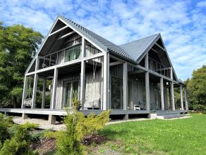a large house with a gambrel roof at Zušu Villa in Bērzciems