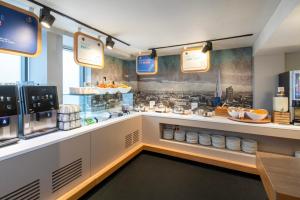 a kitchen with a counter with a breakfast buffet at Holiday Inn Express Southwark by IHG in London +39 photos