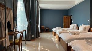 uma fila de camas num quarto com paredes azuis em Look at Home Lamphun em Lamphun