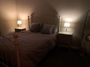 a bedroom with a large bed with two lamps on it at Converted cattle barn overlooking Strangford Lough in Newtownards