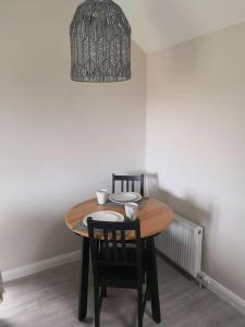 a dining room table with two chairs and a chandelier at Converted cattle barn overlooking Strangford Lough in Newtownards