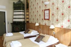 een hotelkamer met 3 bedden en een open haard bij Villa Urhola, Kruunupuisto in Punkaharju