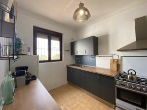a kitchen with black cabinets and a stove top oven at Maison écologique avec piscine in La Puerta de Segura