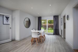 a white dining room with a table and chairs at 3 Bed Private Bungalow Close to Amenities, Wifi, Parking by Ark SA in Sheffield