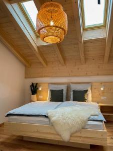 1 dormitorio con cama grande en el techo de madera en Bayerwald Chalet Kaitersberg mit Sauna, Sonnenterrasse und Garten, en Arnbruck