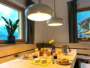 una mesa con platos de comida y vasos de zumo de naranja en Bayerwald Chalet Kaitersberg mit Sauna, Sonnenterrasse und Garten, en Arnbruck