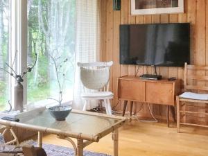 a living room with a flat screen tv and a table at Holiday home SORTLAND III in Sortland