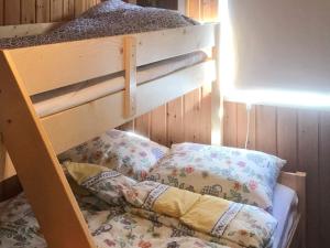 Holiday home SORTLAND III في سورتلاند: سرير بطابقين خشبي مع وسادتين عليه