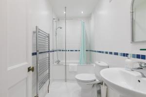 a bathroom with a shower and a toilet and a sink at 4 Pentowan Court in St Ives +26 photos