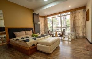um quarto com uma cama, uma cadeira e uma janela em Cozy Gurney Georgetown Private Apartment Penang em George Town