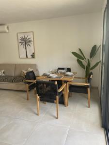 a living room with a table and a couch at Cottage Cosy Duplex Anse Marcel, Vue mer et marina in Anse Marcel 