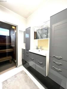 a bathroom with a sink and a mirror at Rentida luxuslik maja. in Tallinn