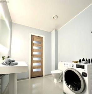 a bathroom with a washing machine and a toilet at Rentida luxuslik maja. in Tallinn