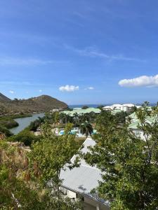 Vista ariale di un resort con fiume e alberi di Cottage Cosy Duplex Anse Marcel, Vue mer et marina ad Anse Marcel
