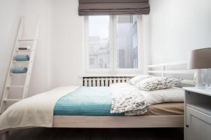 biała sypialnia z łóżkiem i oknem w obiekcie Apartament Zgoda w mieście Gdynia