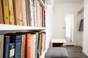 una estantería llena de libros y un taburete en Apartament Zgoda, en Gdynia