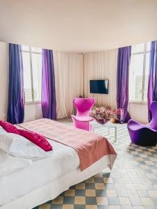 濱海阿熱萊斯的住宿－B&B Château Valmy - Teritoria，一间卧室配有一张大床和紫色家具