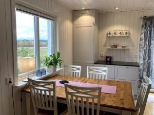 a kitchen with a table and chairs and a large window at Trevlig stuga/gårdshus med egen parkering in Burträsk