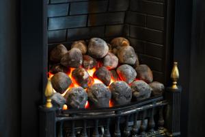 a pile of rocks on a fire in a fireplace at Ferry Nice in Broughty Ferry