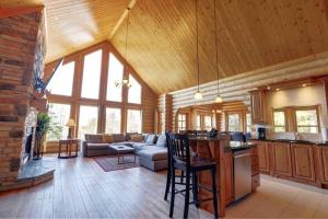ein großes Wohnzimmer mit einem Sofa und einem Tisch in der Unterkunft Fiddler Lake Resort Chalet 96 Elk in Mille-Isles