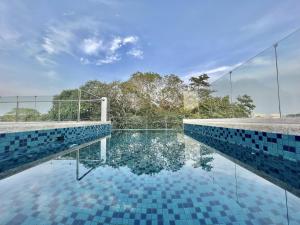 uma piscina com azulejos azuis no chão em Lighthouse Point Hotel em Dumaguete