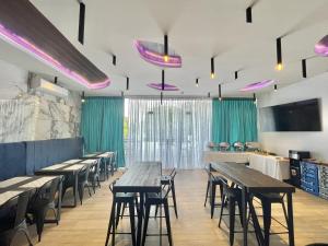 uma sala de jantar com mesas e cadeiras de madeira em Lighthouse Point Hotel em Dumaguete