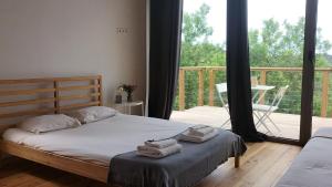 a bedroom with a bed with towels on it and a balcony at Biovilla Sustentabilidade in Palmela