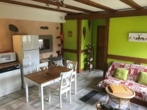 a kitchen and living room with a table and a couch at La Petite Finlande in Orbey