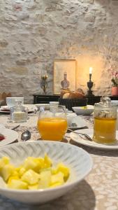LA COUR CARREE في قرقشونة: طاولة مع طبق من الطعام وكأسين من عصير البرتقال