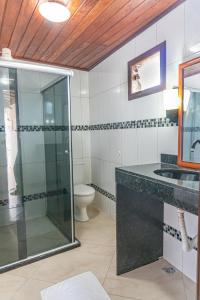 a bathroom with a glass shower and a toilet at Pousada Gute Morro in Morro de São Paulo
