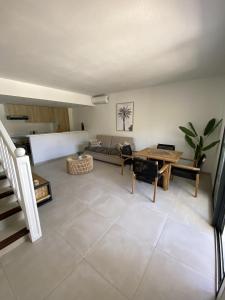 ein Wohnzimmer mit einem Sofa und einem Tisch in der Unterkunft Cottage Cosy Duplex Anse Marcel, Vue mer et marina in Anse Marcel 