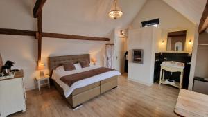 een grote slaapkamer met een groot bed en een wastafel bij B&B De Droomhoeve in Nunspeet