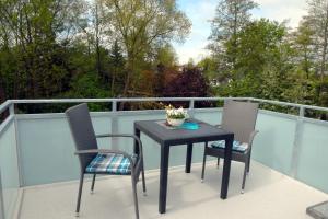 een zwarte tafel en 2 stoelen op een balkon bij Seeschwalbe in Scharbeutz
