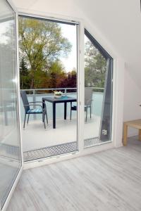 a sliding glass door leading to a patio with a table and chairs at Seeschwalbe in Scharbeutz