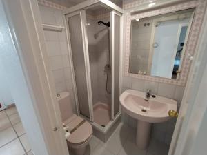 a bathroom with a toilet and a sink and a shower at APTO. DOBLE PLANTA BAJA CON ACCESO A LA PISCINA in Isla Canela +8 photos