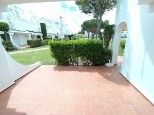 a brick walkway leading to a white building at APTO. DOBLE PLANTA BAJA CON ACCESO A LA PISCINA in Isla Canela