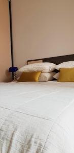 ein Bett mit weißer Bettwäsche und Kissen darauf in der Unterkunft Diva Petra Apartment in Budva
