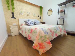 a bedroom with a bed with a floral bedspread on it at Apartamento para 3 en pleno centro de Sevilla in Seville