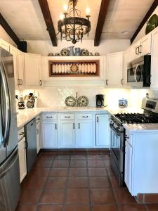 a kitchen with white cabinets and a stove top oven at Casa De Vito in Palm Springs