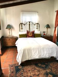 a bedroom with a large white bed and two lamps at Casa De Vito in Palm Springs